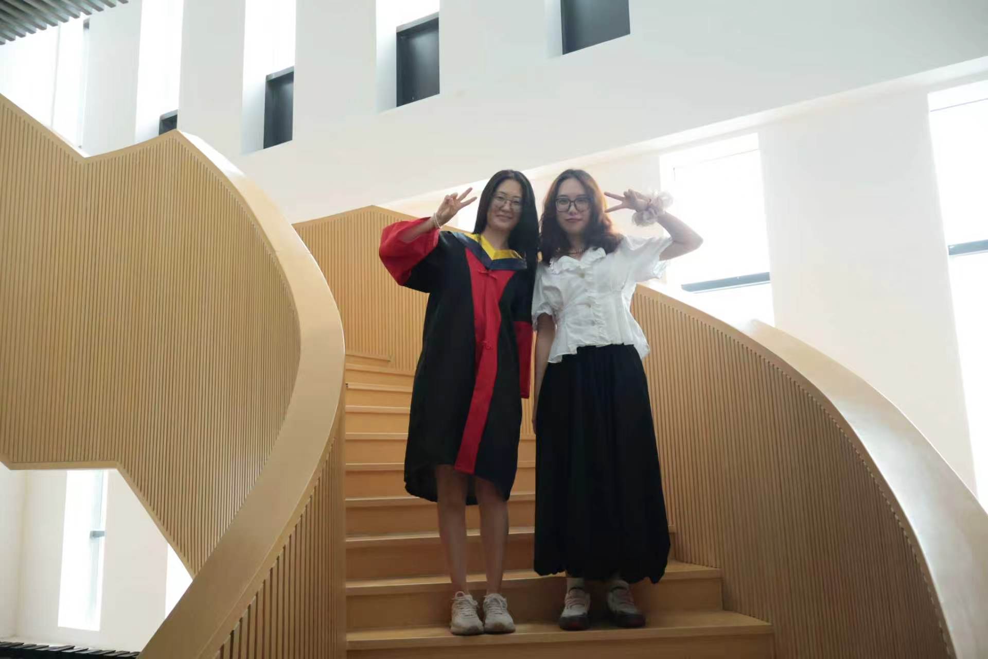 曹馨尹和同学在楼梯上合影比耶
