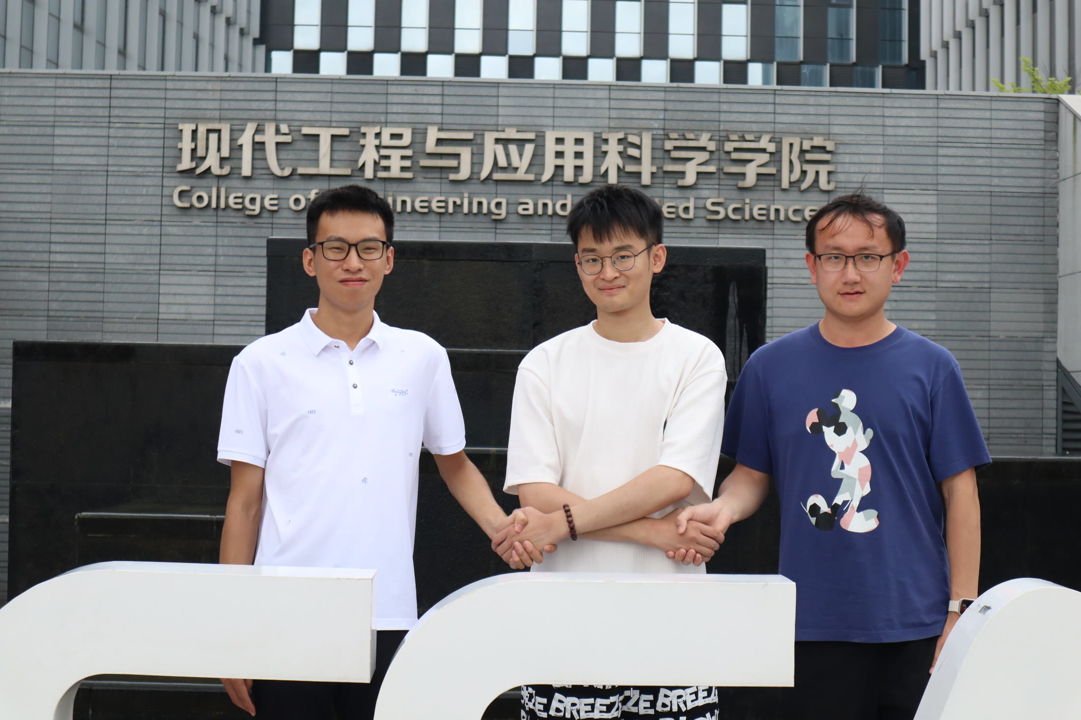 学院门前的三人合影，队形很稳